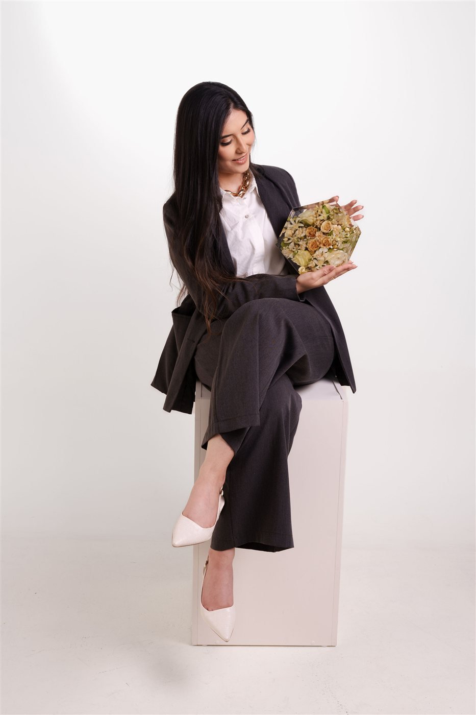 Izabela Evangelista em estúdio segurando um bouquet preservado em resina