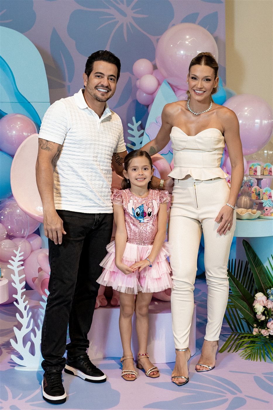 Família sorrindo em festa de aniversário infantil com identidade visual personalizada