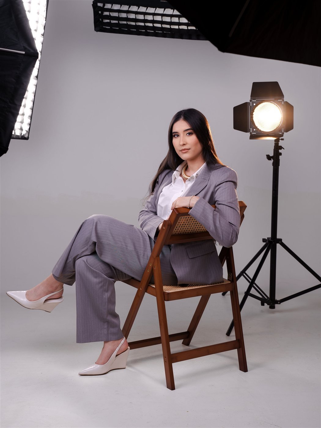 Izabela Evangelista em estúdio fotográfico, com equipamento de iluminação ao fundo